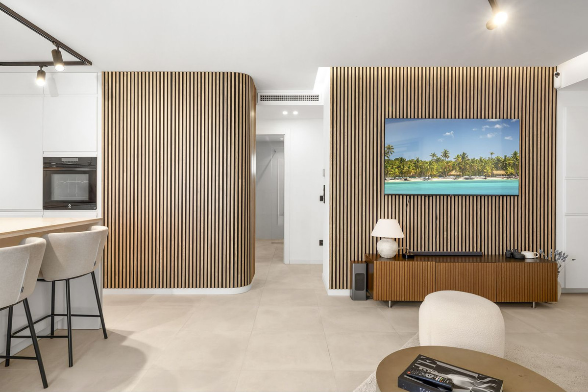 Open-plan living area with curved oak-slat walls dividing the hallway
