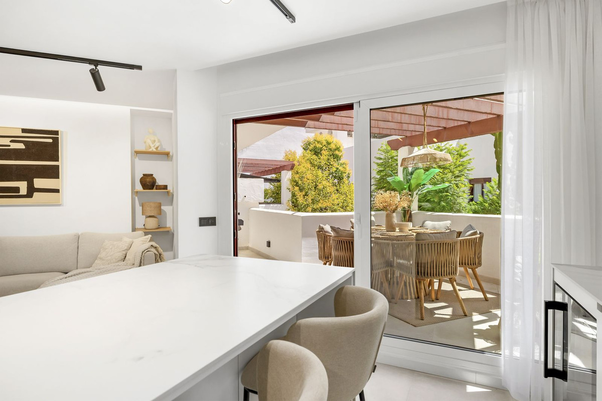 Living area looking out through sliding doors to the planted terrace
