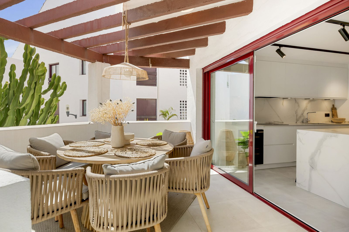 Covered terrace with dining set beside sliding doors to the kitchen